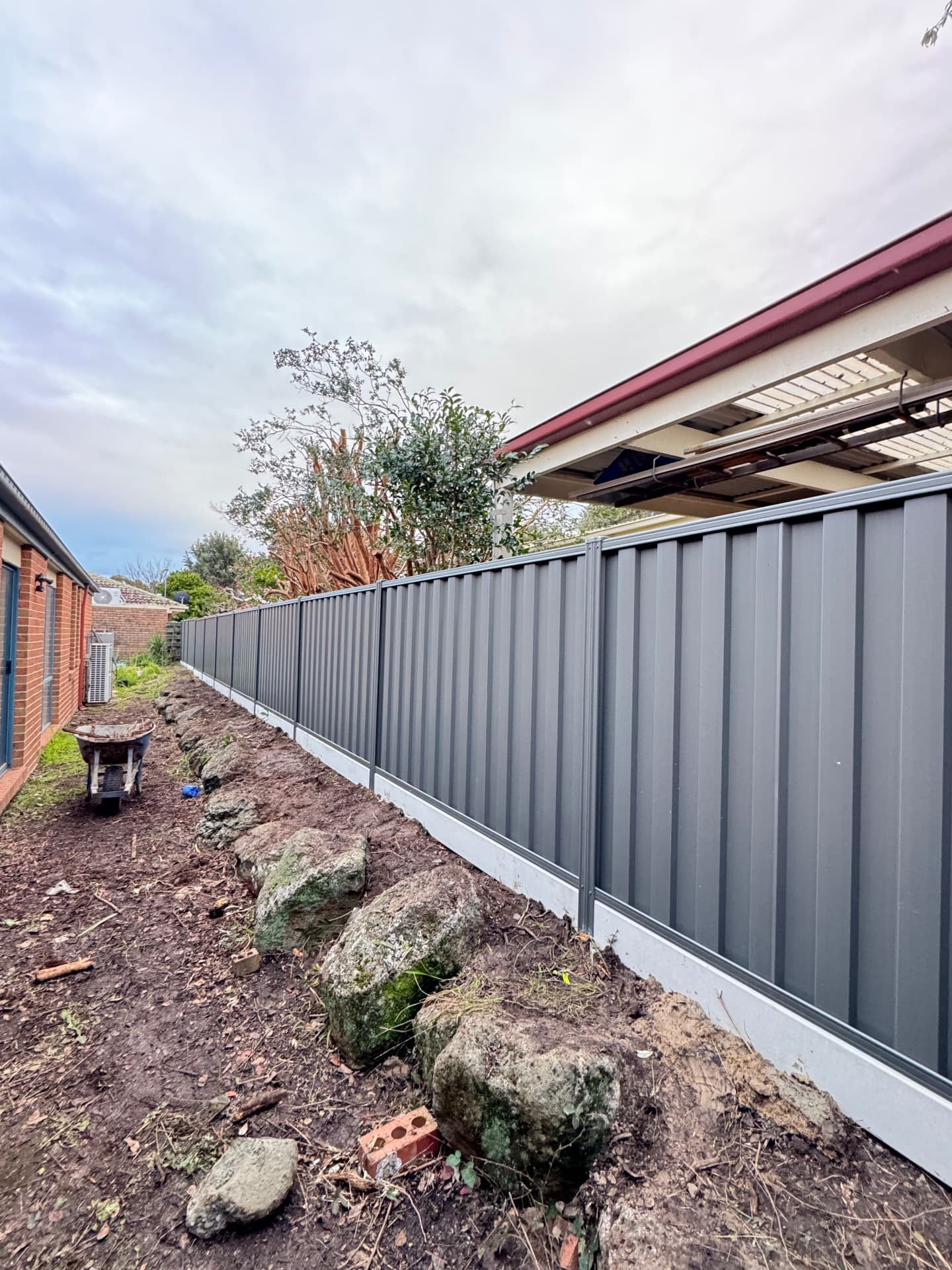Monument Colorbond fence installed along a side boundary with concrete plinths
